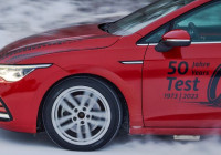 červený automobil jedoucí po zasněžené vozovce